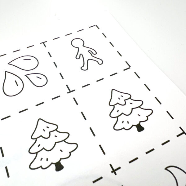 A close up on the corner detail of a page with colour and cut out black and white emoji